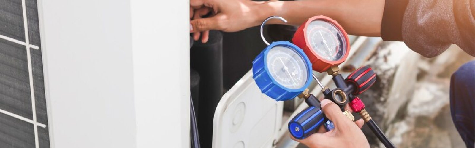 HVAC technician using gauges to service an air conditioning unit, emphasizing emergency HVAC service and maintenance in Thousand Oaks.
